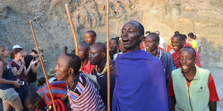 Students observing locals perform the maasai dance in Tanzania