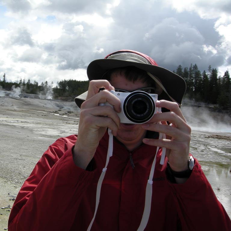 Man holding a camera in front of his face to take a picture